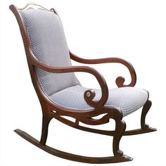 a wooden rocking chair with blue and white patterned upholstered fabric on the seat