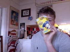 a young man holding up a box of cereal