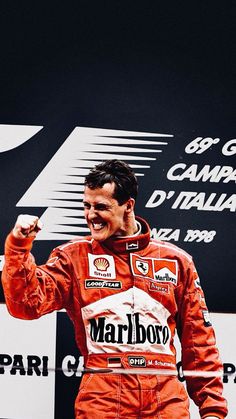 a man standing on top of a race track holding his fist up in the air