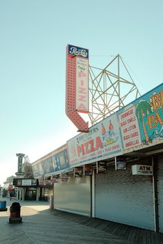 a pizza parlor with signs on the side of it