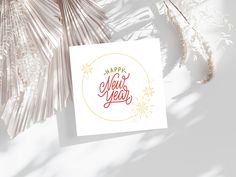 a greeting card with the words happy new year on it next to some dried plants