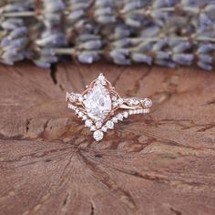 a close up of a ring on top of a tree stump with lavender flowers in the background