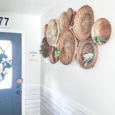 several baskets are hanging on the wall above a door