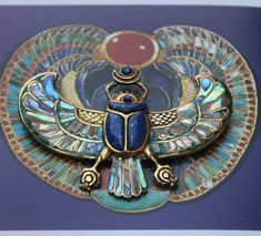 A stunning hand-carved jewel inspired by an ancient Egyptian work of art. This pendant will make you feel like a living goddess The design is so intricate and powerful. The masterpiece was carved in wood and then molded to reproduce in brass. Abalone shell incrustations fit perfectly in the gaps of the wings, bringing a touch of light and glitter to this majestic piece. The legendary figure of the scarab Kephri is inlaid with genuine lapislazuli cut perfectly to fit the gaps. It also holds aroun Winged Scarab, Egyptian Revival Jewelry, Abalone Shell Necklace, Egyptian Necklace, Egyptian Scarab, Tutankhamun, Horn Necklace, Egyptian Jewelry, Mother Of Pearl Necklace