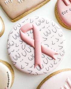 decorated cookies with pink icing on white surface