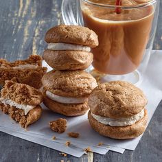 a stack of cookies next to a glass of iced tea and cinnamon roll on a napkin