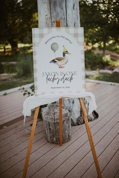 a sign that is sitting on top of a wooden easel in front of a tree