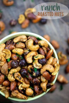 roasted nuts in a green bowl on a wooden table with the words ranch roasted nuts above it