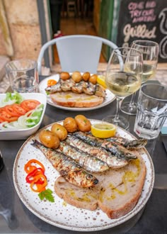 a table topped with plates of food and glasses of wine