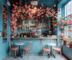 the interior of a restaurant with blue walls and flowers hanging from the ceiling