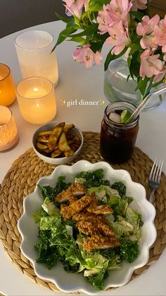 a white plate topped with lettuce next to a bowl filled with meat and potatoes