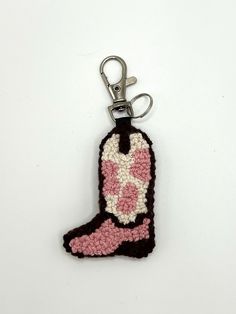 a crocheted keychain with a pink boot on the front and black bottom