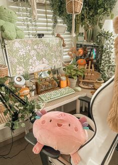 a stuffed animal sitting on top of a chair in front of a desk with plants