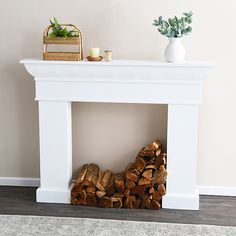 a white fireplace with logs in front of it