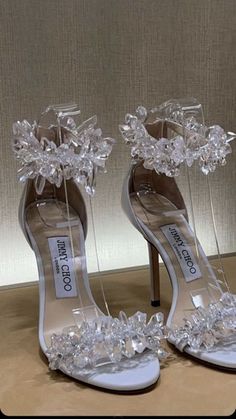 a pair of high heeled shoes with flowers on the toes and ankle straps