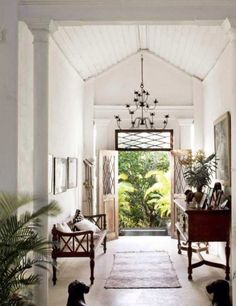 an open door leading into a room with white walls and ceiling tiles on the floor