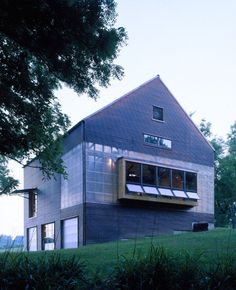 the house is made out of wood and has large windows on it's roof