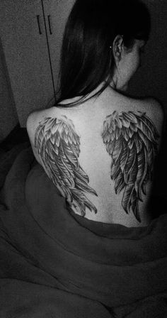 the back of a woman's body with large wings on her upper and lower back