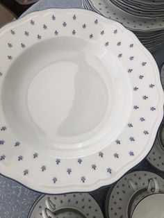 a table topped with lots of white and blue plates covered in saucer cups on top of each other