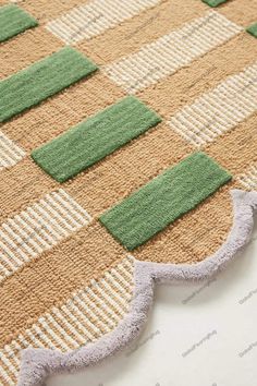 a close up view of a rug with green and white squares on the bottom half