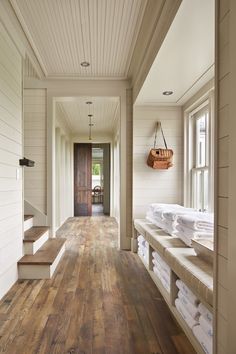 a long hallway with wooden floors and white walls