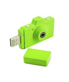 a green digital camera sitting next to a flash drive