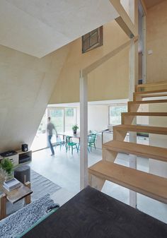 a person is walking up some stairs in a room with wood floors and white walls