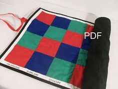 a black and red bag sitting on top of a white sheet