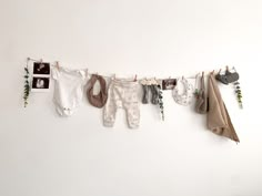 baby clothes hanging on a clothes line with pictures and plants