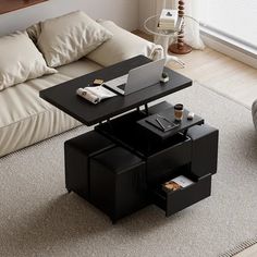 a living room with a couch, coffee table and laptop on top of the table