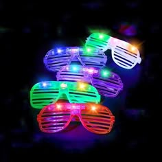 three pairs of neon colored glasses with lights on them