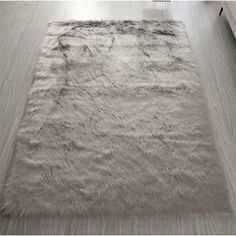 an area rug is shown in the middle of a room with white walls and wood floors