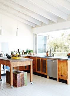 a kitchen with wooden cabinets and an island in front of a window that has fruit on it