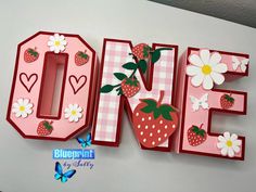 the letter e is made out of paper and decorated with strawberries, flowers, and hearts