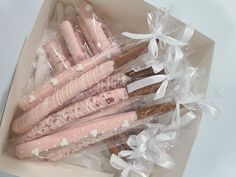 a box filled with pink and white decorated cookies