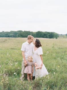 a couple and their two children standing in a field