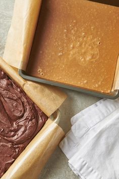 two pans filled with chocolate frosting next to each other on top of a table