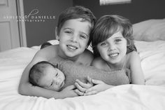 two young children laying on top of a bed with their arms wrapped around each other