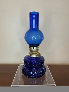 a blue glass vase sitting on top of a wooden table