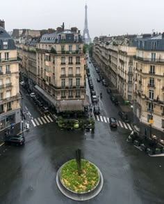 an aerial view of a city with tall buildings and cars on the street in front of it