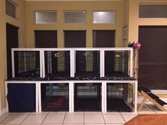 a room filled with lots of cages on top of tiled floor next to a wooden table