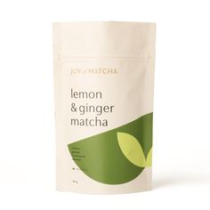 a bag of lemon and ginger matcha sitting on a white surface with green leaves