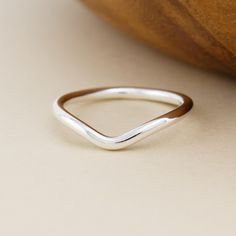 a silver ring sitting on top of a table next to a piece of wood and a banana