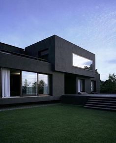 an image of a modern house taken from the ground level, with grass and steps leading up to it