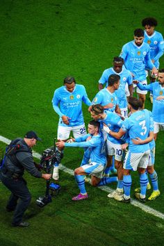 a group of soccer players huddle together on the field