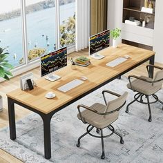 a table with two chairs and a laptop on it in front of a window overlooking the water