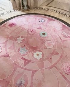 the floor is covered in pink and white tiles with flowers on them, as well as an ornamental design