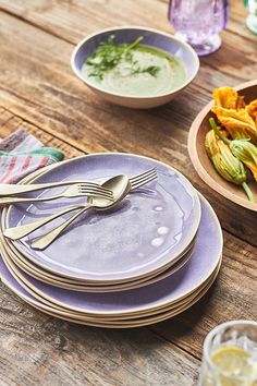 purple plates and silverware on a wooden table