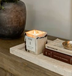 a candle sitting on top of a table next to books