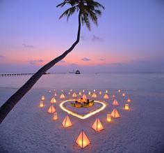 a heart - shaped candlelight display on the beach with text that reads, what's your gill story?